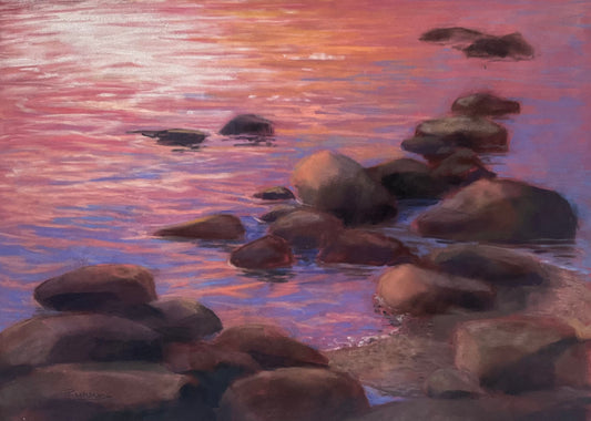 Rocks in water with a pink and purple sunset reflection