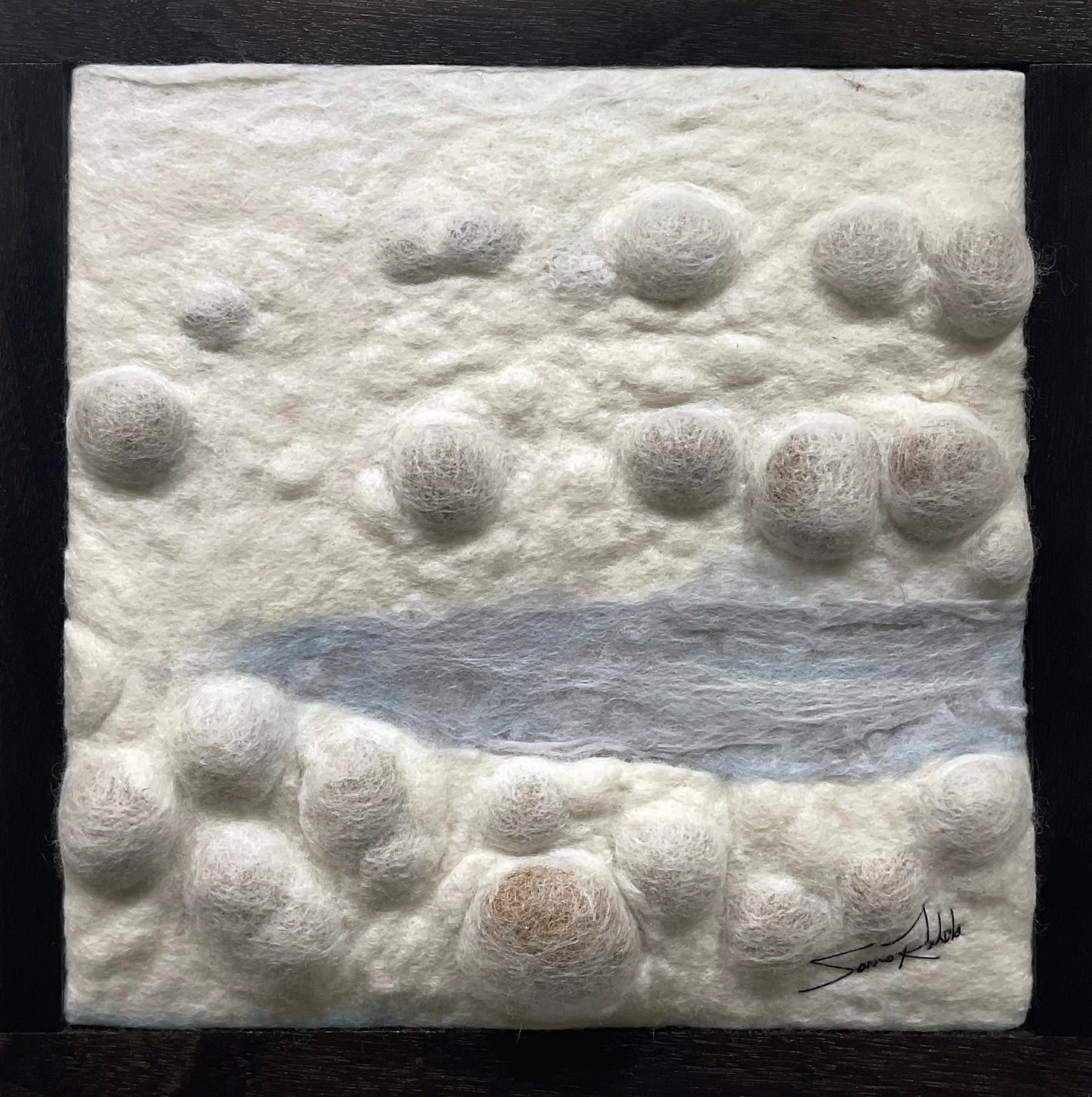 Textured white surface with circular patterns and a central blue line, signed by the artist on a black background.